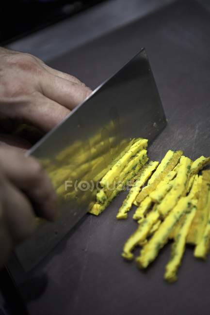 Vue rapprochée des mains tranchant une omelette en lanières — Photo de stock