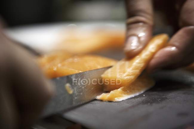 Raw salmon being cut — Stock Photo