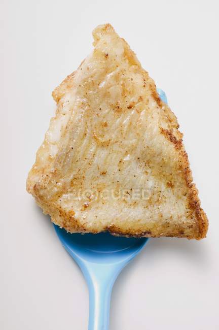 Filet de poisson frit sur spatule bleue — Photo de stock