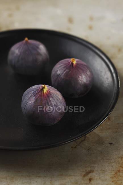 Higos frescos en plato negro - foto de stock