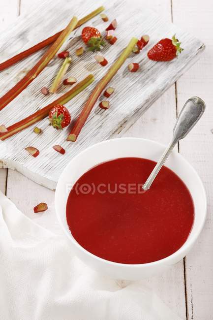 Closeup view of rhubarb and strawberry soup in a bowl with a spoon — Stock Photo