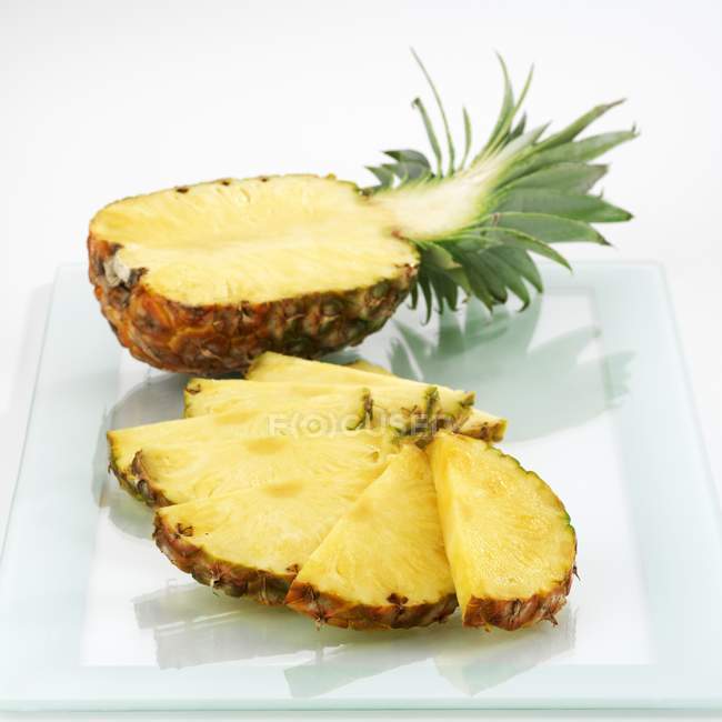 Half pineapple and pineapple slices — Stock Photo