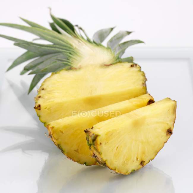 Half pineapple partly sliced — Stock Photo