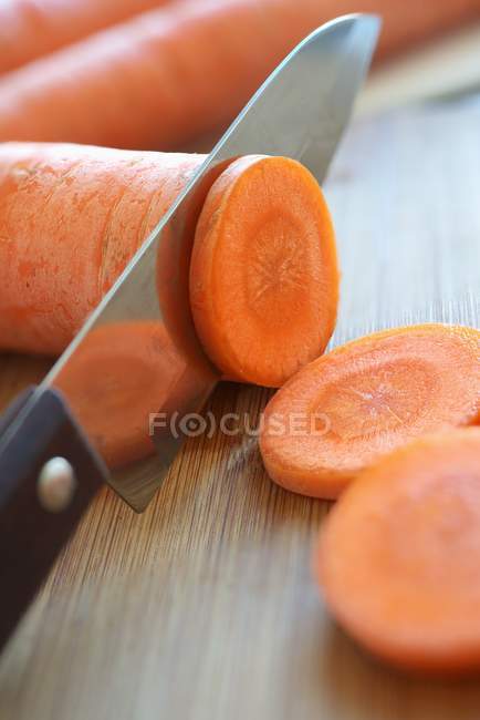 Partly sliced carrot with knife — Stock Photo