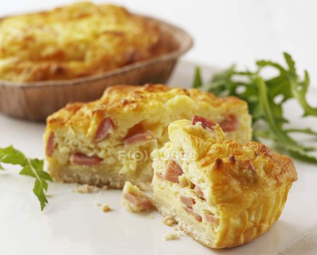 Quiche Lorraine pieces with herb on white surface — Stock Photo