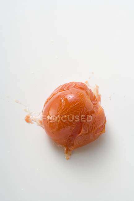 Gekochte Tomate auf weißer Oberfläche geplatzt — Stockfoto