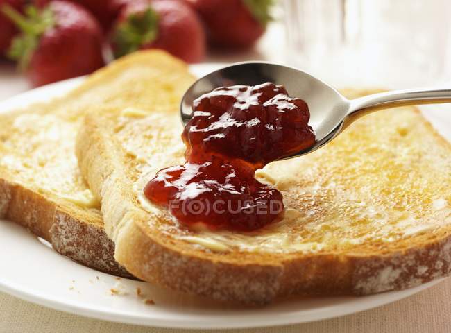 Nahaufnahme von Toasts mit Butter und Erdbeermarmelade — Stockfoto