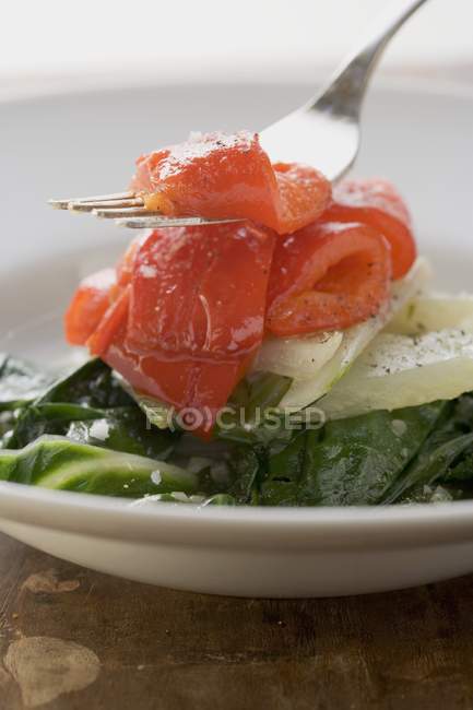 Vegetable tower - chard, braised peppers on white plate and fork — Stock Photo