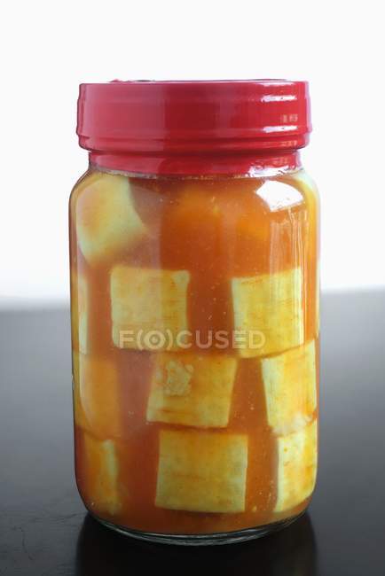 Primo piano vista di un vaso di vetro chiuso di tofu marinato — Foto stock