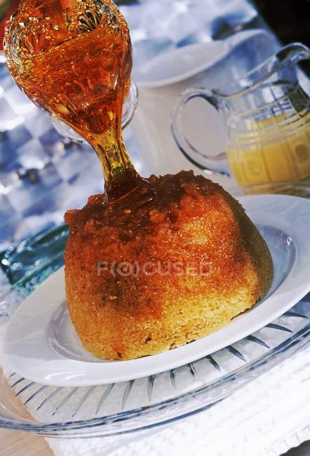 Golden syrup poured onto pudding — Stock Photo