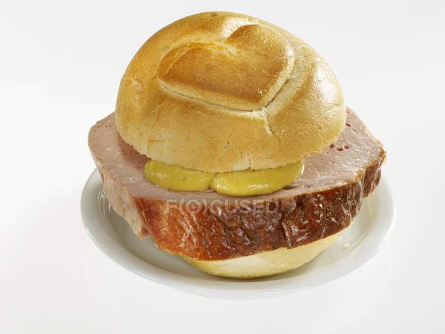 Closeup view of Leberkse meatloaf in bread roll with heart — Stock Photo