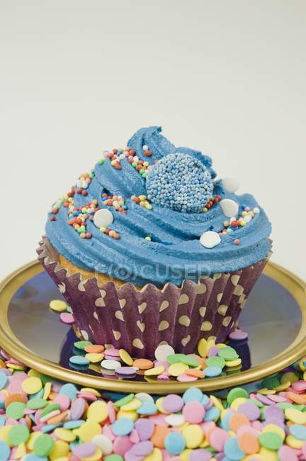 Cupcake decorated with sprinkles and sweets — Stock Photo
