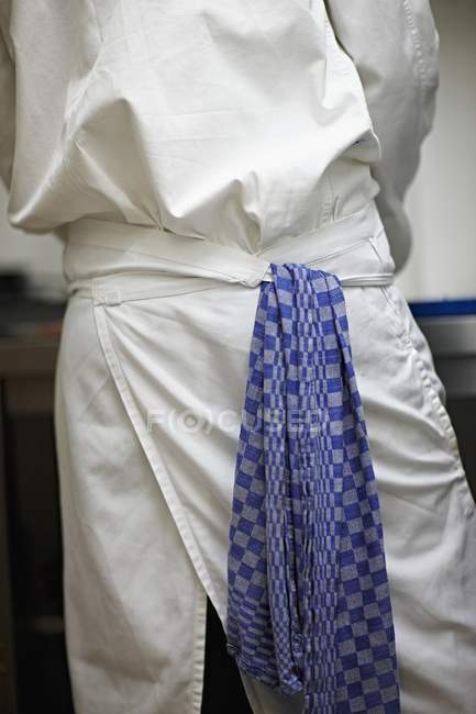 Abgeschnittene Rückansicht eines Kochs mit einem Geschirrtuch, das an seiner Schürze hängt — Stockfoto