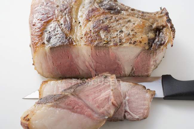 Teilweise in Scheiben geschnittenes gebratenes Schweinekotelett — Stockfoto