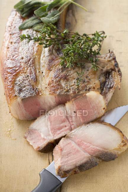 Partly sliced Pork chop with herbs — Stock Photo