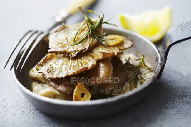 Fried oyster mushrooms in small frying pan over grey surface — Stock Photo