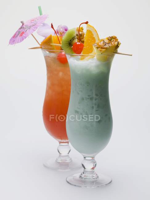 Two Caribbean long drinks with fruit skewers in glasses — Stock Photo