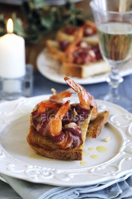 Crostini with prawns in bacon — Stock Photo