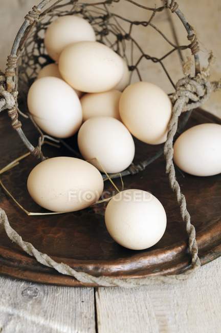 Яйця падають з дротяного кошика — стокове фото