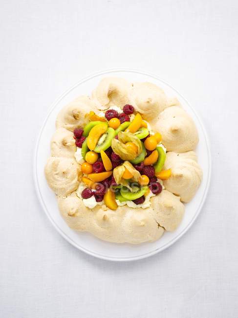 Pavlova con frutas frescas en plato blanco - foto de stock