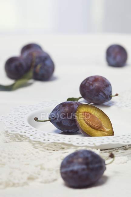 Fresh Damsons on lace plate — Stock Photo
