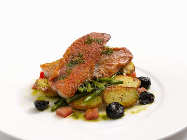 Red mullet fillet on bed of potatoes — Stock Photo