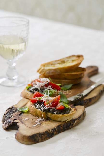 Bruschetta with a trio of tomatoes and tapenade on table — Stock Photo