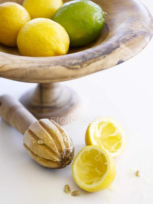 Limões e limas em tigela de madeira — Fotografia de Stock