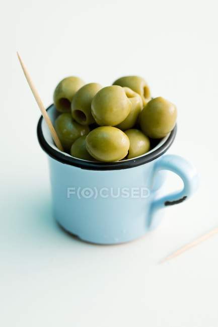 Зелені оливки в кухоль — стокове фото