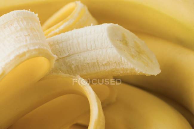 Plátanos frescos medio pelados - foto de stock