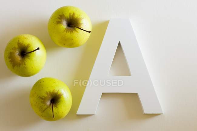 Manzanas verdes y letra A - foto de stock