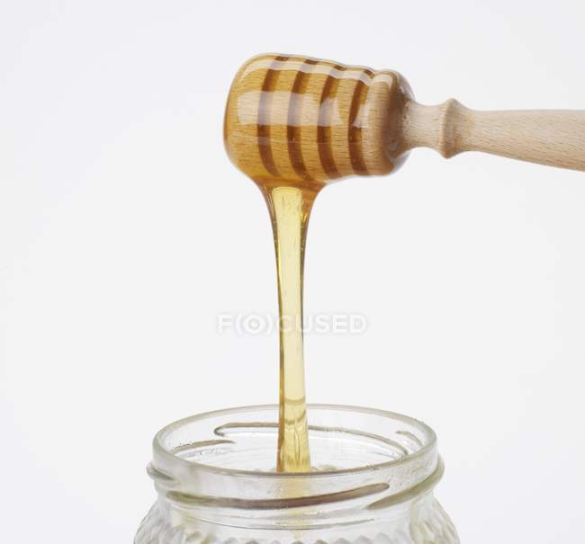 Honey running from dipper — Stock Photo