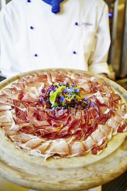 Chef serving ham platter — Stock Photo