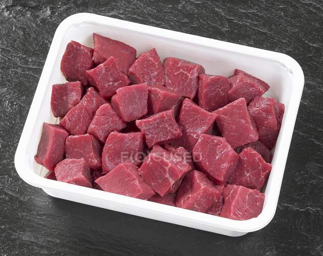 Bife em cubos em recipiente de plástico — Fotografia de Stock