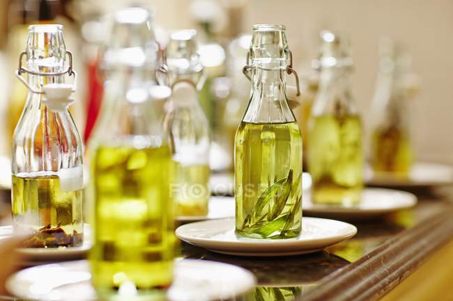 Closeup view of various bottles of oil on saucers — Stock Photo