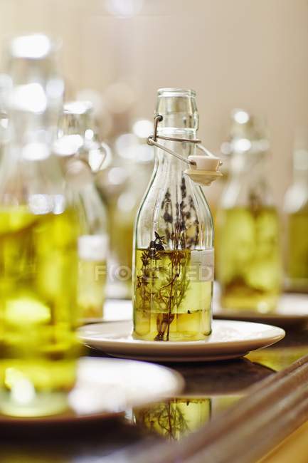 Vista close-up de várias garrafas de óleo em pires — Fotografia de Stock