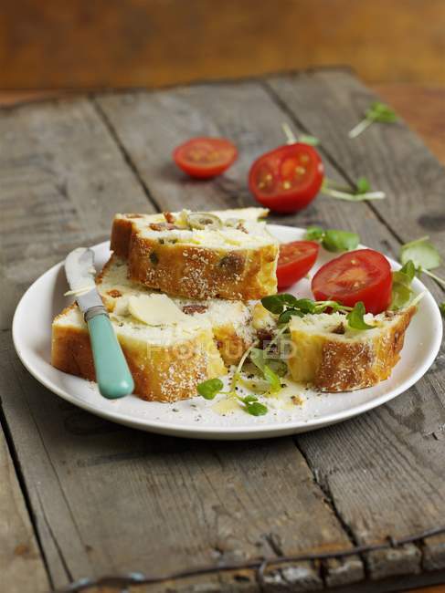 Glutenfreies Olivenbrot auf weißem Teller über Holzoberfläche — Stockfoto