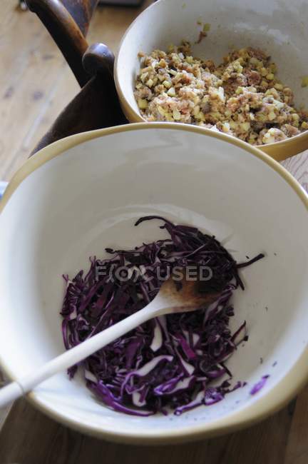 Closeup view of sliced red cabbage in a bowl with a wooden spoon — Stock Photo