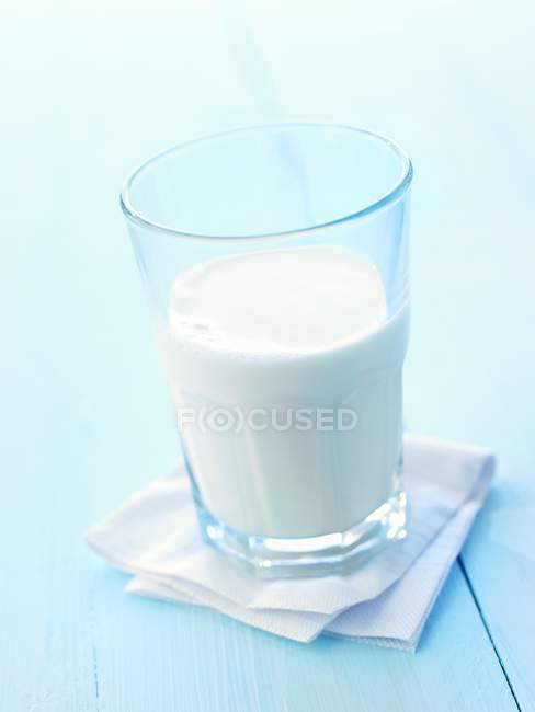 Verre de lait sur surface blanche — Photo de stock