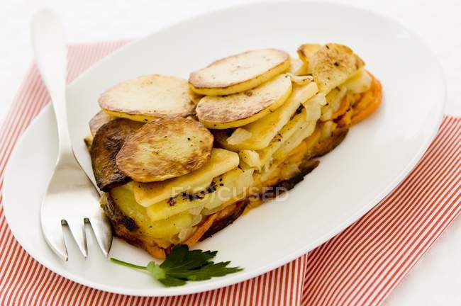 Um pedaço de batata-doce e torta de batata branca em uma placa branca sobre toalha — Fotografia de Stock