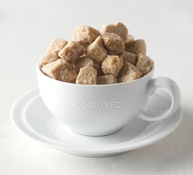 Cubos de açúcar marrom na xícara — Fotografia de Stock
