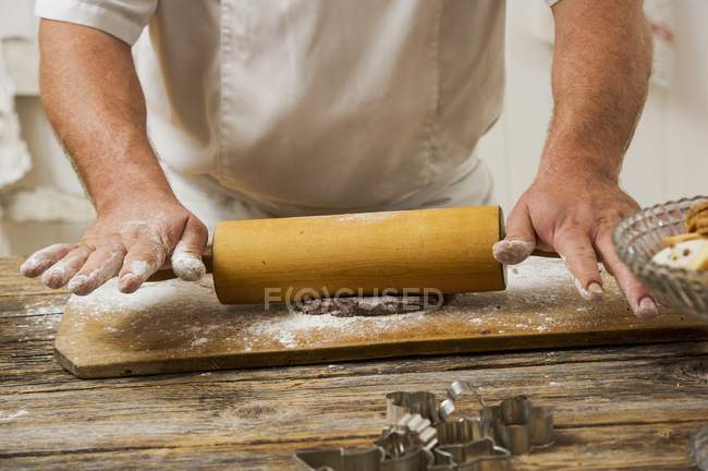 Cropped view of a confectioner rolling out biscuit dough — Stock Photo