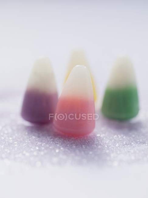 Vista de primer plano de maíz caramelo sobre azúcar granulada púrpura - foto de stock