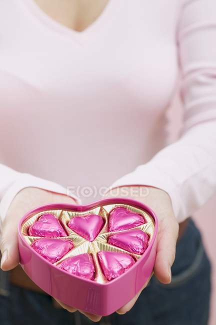 Woman holding box of chocolates — Stock Photo