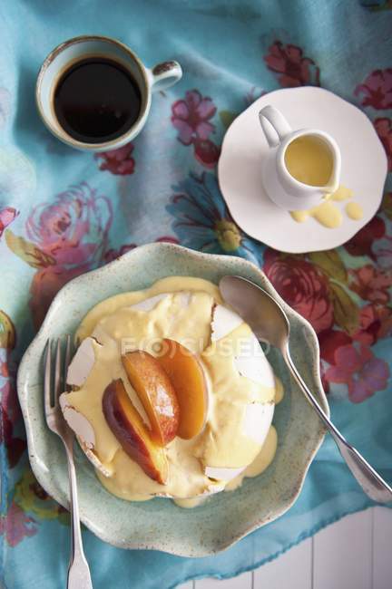 Вид сверху на Павлову с ванильным соусом и ломтиками персика — стоковое фото
