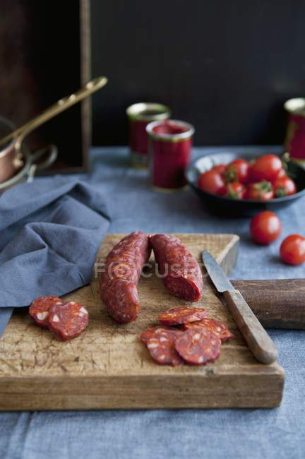 Vista elevada de salsichas curadas com páprica em uma tábua de corte — Fotografia de Stock