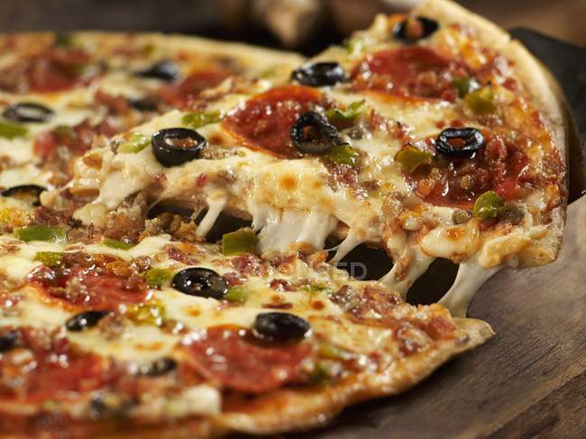 Горячая пицца с салями и оливками — стоковое фото