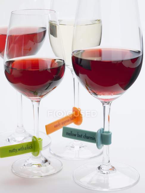 Vista de cerca de copas de vino con etiquetas de plástico - foto de stock