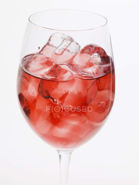 Copa de vino rosa con cubitos de hielo - foto de stock
