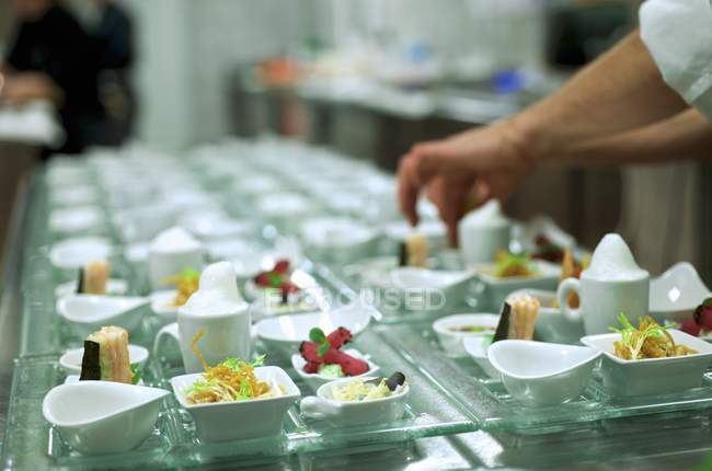 Vista cortada de um chef organizando entradas em um buffet — Fotografia de Stock